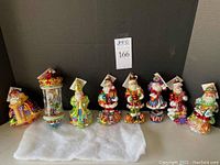 Eight ornaments lined up on shelf against dark background