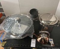 Photo showing all items together: double boiler pot with lid, two small metal ramekins, rose gold tea pot in original box, electric wok