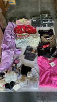 Full lot overview showing bras, dresses, gloves, half slips, bathrobe, sweaters, and caps