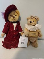 Both collectible bears posed side-by-side against a white background, showing the clothing and overall appearance.