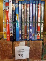 Front view of 15 children's and family DVD cases aligned vertically showing titles and cases.