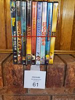 Spine view of the DVDs showing titles Batman, Brother Bear 2, Narnia, Mulan, Bedtime Stories, Lilo & Stitch, The Emperor's New Groove, Bolt.