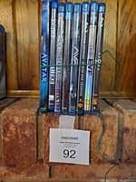 Front view of 8 sci-fi movie Blu-ray and DVD cases tightly bundled together with a rubber band.
