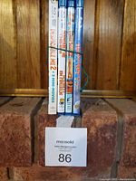 Side view of 4 movie cases showing titles and condition, tied with a string.