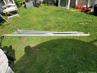Metal shelving and outlet bars laid out on grass for sale.
