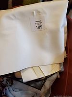 Large roll of white vinyl fabric on top of assorted folded materials