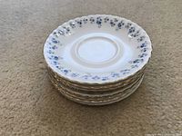 Stack of 8 Royal Albert Memory Lane saucers showing pattern and gold trim