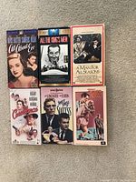 Front covers of 6 classic VHS tapes arranged on carpet: All About Eve, All the King's Men, A Man for All Seasons, Casablanca, Sweet Smell of Success, Touch of Evil.