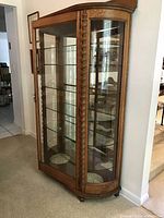 Front side view showing entire oak china cabinet with curved glass front and wood spiral pilasters on each side.