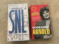 Front covers of two Saturday Night Live VHS tapes: '25 Years of Laughs' with a montage style cover and 'Best of SNL' featuring Roseanne Arnold.