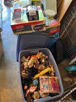 Blue plastic bin filled with loose Ty plush toys and visible packaged Beanie Babies collectible pack