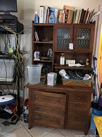 Full view of two-section oak cabinet with glass doors, drawers, lower cabinet and surrounding items
