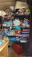 Full view of black metal shelving unit filled with assorted fabrics
