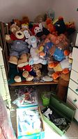 Wide shot of stuffed animals piled on shelf with craft supplies beneath