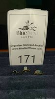 Three rings displayed on black ring holder with auction lot sign 171