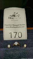 Photo showing ring and matching stud earrings with opal-like stones on blue velvet surface.