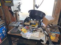 Overview of drill press and surrounding tools on workbench