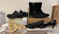 Photo showing the complete set of four pairs of women’s shoes including black UGG boots, black clogs, tan moccasins, and patent low heels, all size 9.5.