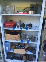 Four metal shelves filled with assorted household items and tools.