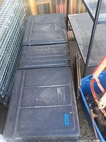 Top view photo of large black plastic truck tool box with two lids marked 'Better Built'.