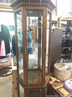 Photo showing front and side views of a six-shelf lighted display cabinet with wooden frame and glass panels including mirrored back panel.