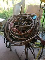 Photo showing multiple coiled brown and orange air hoses gathered on stand