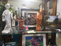 Display with three statues and two framed pictures