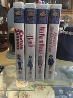 Front view of 4 VHS tapes showing titles and shrink wrap intact.