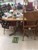 Full view of mahogany dining table with wooden chairs around it, showing wood finish and legs.
