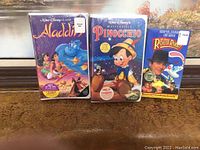 Photo of three sealed VHS tapes: Aladdin, Pinocchio, and Who Framed Roger Rabbit