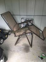 Full side view of the anti gravity lounge chair showing its shape, fabric, frame, and adjustable recline mechanism.