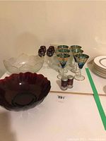 Overall shot showing red salt shakers, blue and gold wine glasses, clear and dark red serving bowls