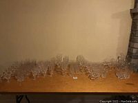 Wide view of entire crystal glassware set on wooden surface