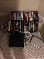 Photo of DVDs and VHS collection along with Samsung DVD player and Insignia portable DVD player