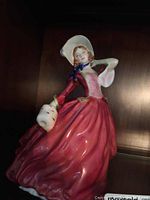 Front and side view of Royal Doulton Autumn Breezes figurine showing details of dress and bonnet.