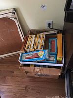 Cardboard box containing multiple boxed train items and track pieces