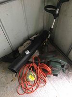 Yardworks electric weed eater, Black & Decker blower/vacuum, extension cords, bag, and trimmer line displayed in corner.