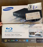Box of Samsung Blu-ray Disc Player BD-F5700 showing brand, model, and wireless LAN built-in features.