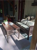 Overview of loveseat and coffee table on screened porch
