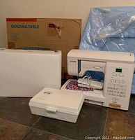 Overview: machine, carrying case, accessory box, quilting table box and wrapped item