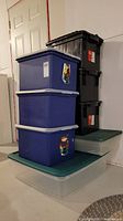 Full view of stacked totes including black tool totes, blue file totes, clear totes with green lids.