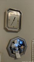 Wall mounted Heirloom branded clock above matching silver-toned octagonal mirror, shows condition and design