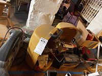 View of various items on table including yellow Coleman lantern case, car heater, and other lot items