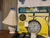 Photo showing the table lamp next to the boxed One Stop Gardens train station clock.