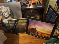 Large Marilyn Monroe portrait print and three other pieces including two scenic prints and a large round wall clock.