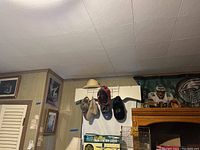 Wide view showing hats on wall hooks, framed wall art, and portion of Eagles banner.