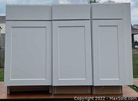 Front view of three white Diamond Now cabinets grouped together showing front shaker-style doors and uniform height of 36 inches.