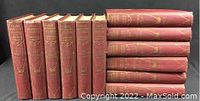 12 red hardcover volumes of Craig Kennedy Stories by Arthur B. Reeve, arranged standing and lying horizontally showing the titles embossed in gold on spines. The books show wear consistent with age.