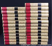 Photo shows all 25 volumes stacked horizontally, with spine labels in red and black against beige covers.