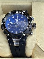 Front view of watch on cushion inside original yellow Invicta box